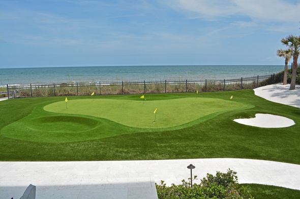 Huntsville Synthetic grass golf green by the sea with yellow flags and a sand bunker