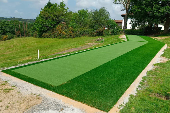 Huntsville Outdoor tee line consisting of one continuous green synthetic grass strip surrounded by trees